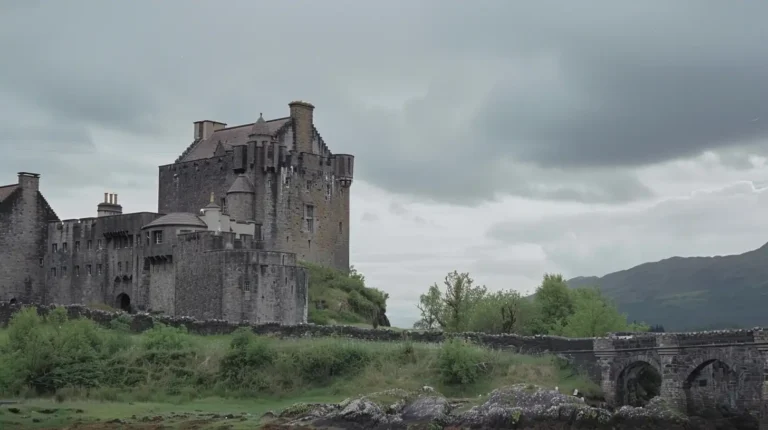 An old stone castle stands on a grassy knoll under a cloudy sky. The castle has tall, narrow windows and towers with conical roofs. A stone bridge with arches connects the castle to the nearby land, surrounded by lush green vegetation. Majestic hills rise in the background, perfect for your AI trip planner to explore. - easytrip.ai